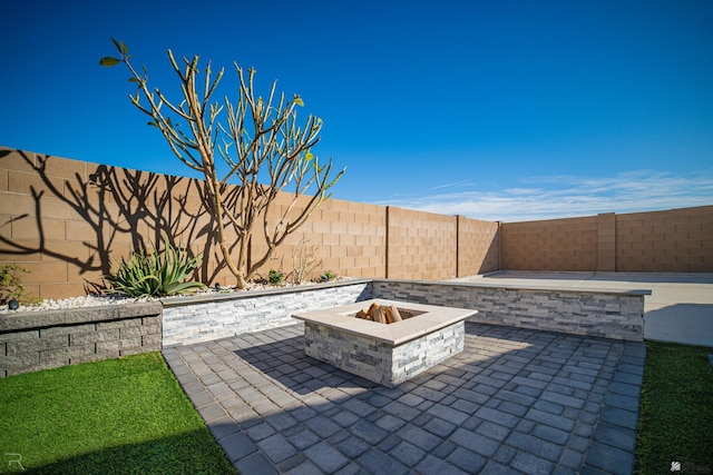 view of patio with an outdoor fire pit and a fenced backyard