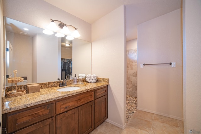 full bath with vanity, baseboards, and walk in shower