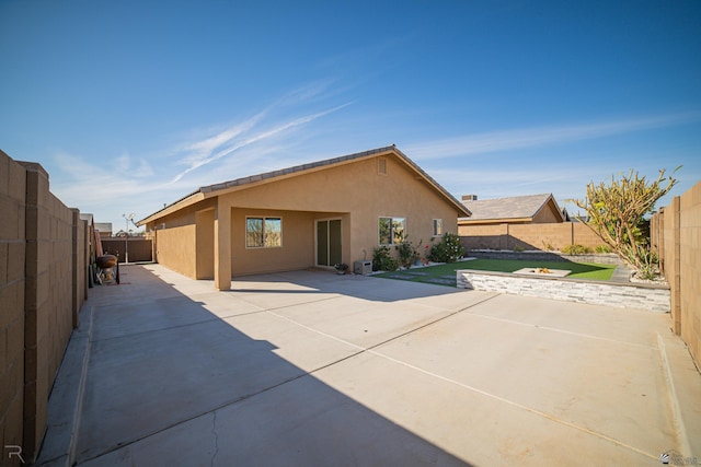 back of property with stucco siding, a patio area, and a fenced backyard