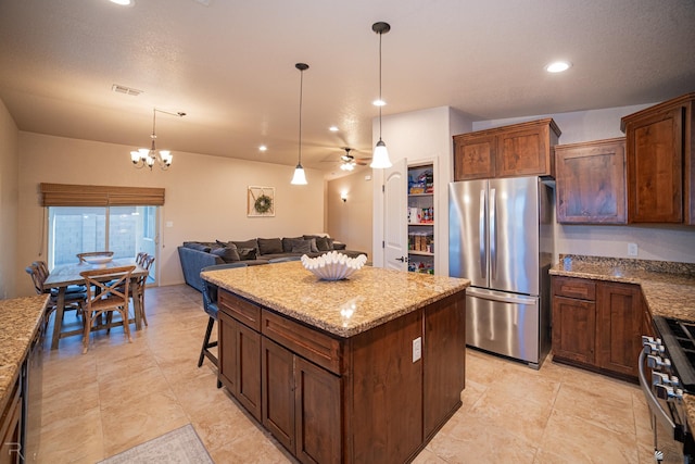 kitchen featuring light stone countertops, open floor plan, a center island, and appliances with stainless steel finishes