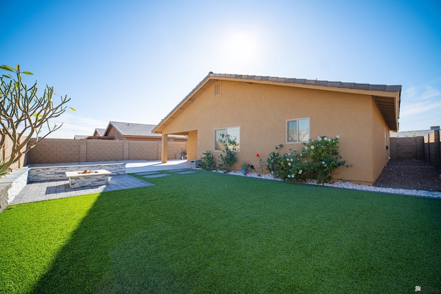 rear view of property featuring stucco siding, a patio area, and a fenced backyard