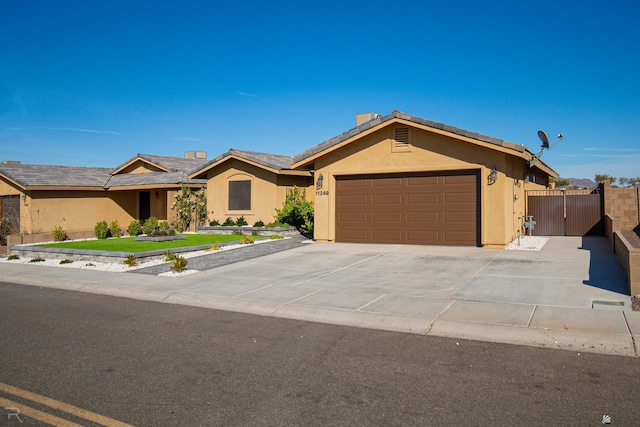 ranch-style home with stucco siding, a gate, driveway, and a garage