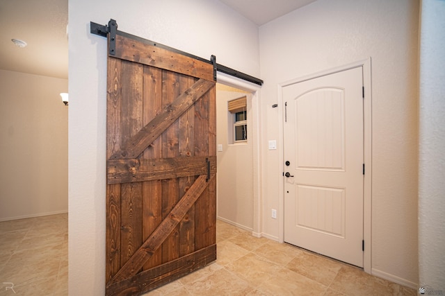 foyer featuring baseboards and a barn door