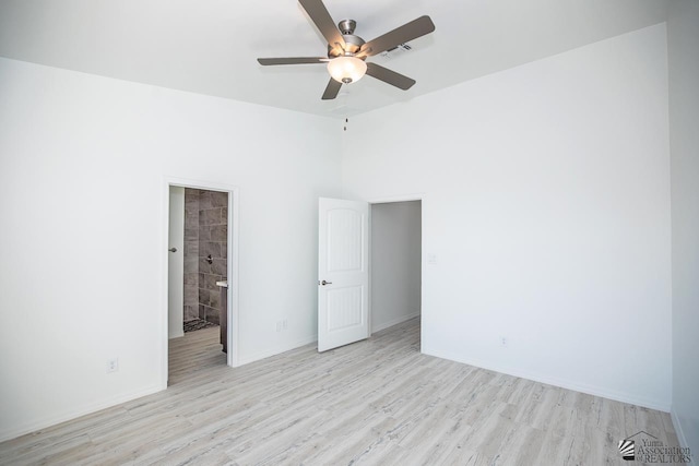 unfurnished bedroom with ceiling fan, ensuite bathroom, and light hardwood / wood-style floors