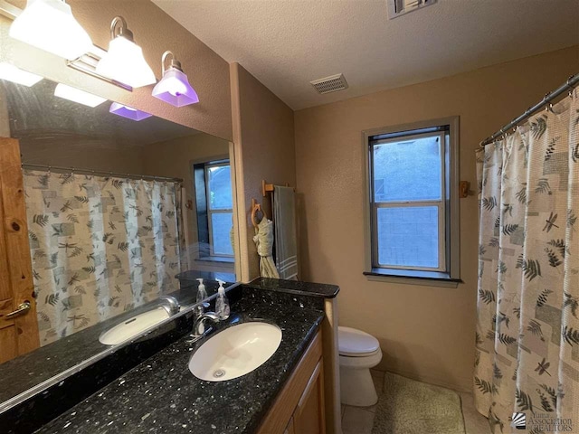 bathroom featuring a shower with curtain, vanity, toilet, and a textured ceiling