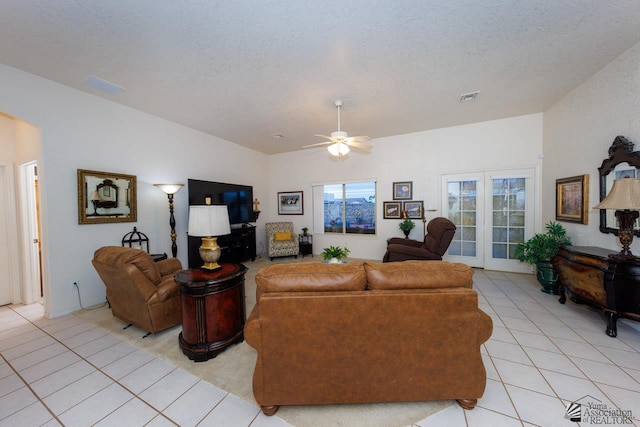 living room featuring ceiling fan, light tile patterned floors, and a textured ceiling