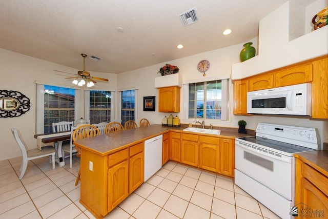 kitchen featuring sink, white appliances, ceiling fan, light tile patterned flooring, and kitchen peninsula