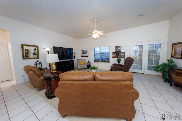 living room with ceiling fan, light tile patterned floors, and a textured ceiling