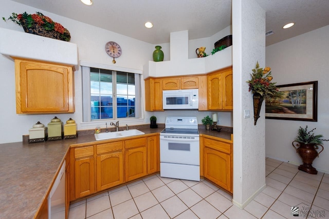 kitchen with sink, light tile patterned floors, and white appliances