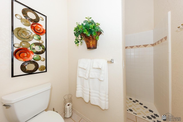 bathroom with tiled shower, tile patterned floors, and toilet