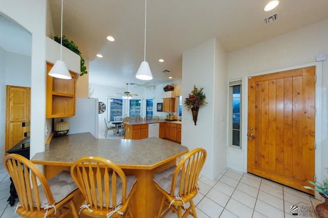 kitchen with white dishwasher, hanging light fixtures, light tile patterned floors, and kitchen peninsula