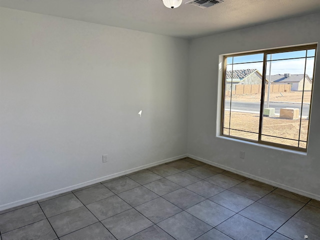 empty room featuring a healthy amount of sunlight and light tile patterned floors