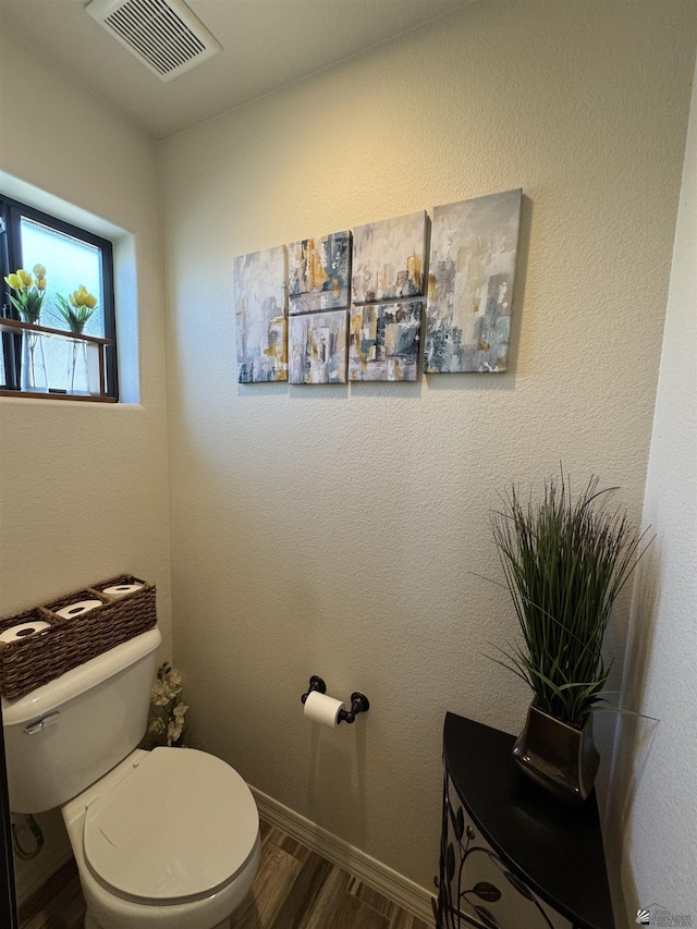 bathroom with wood-type flooring and toilet