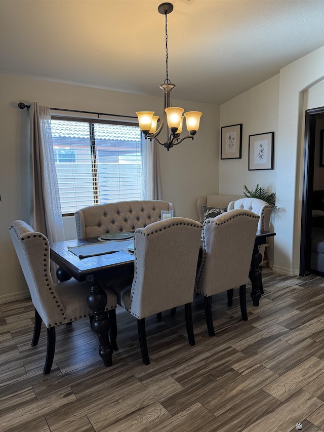 dining area featuring dark hardwood / wood-style flooring, a chandelier, and vaulted ceiling