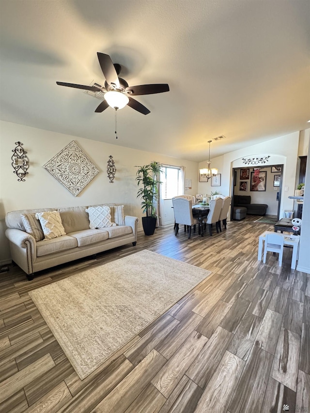 living room featuring hardwood / wood-style flooring and ceiling fan with notable chandelier