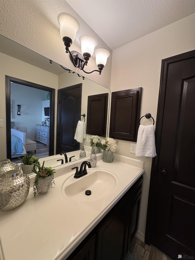 bathroom with vanity, a textured ceiling, and a chandelier