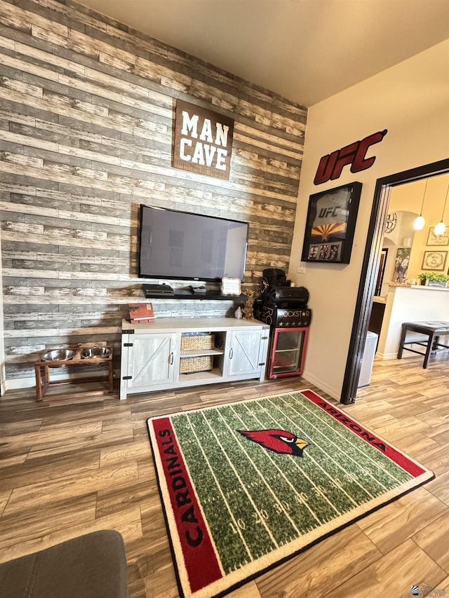 living room featuring wood-type flooring and wooden walls