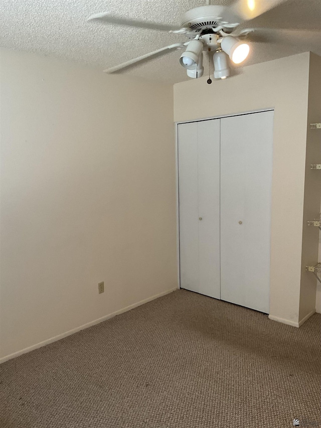 unfurnished bedroom featuring ceiling fan, carpet floors, a textured ceiling, and a closet