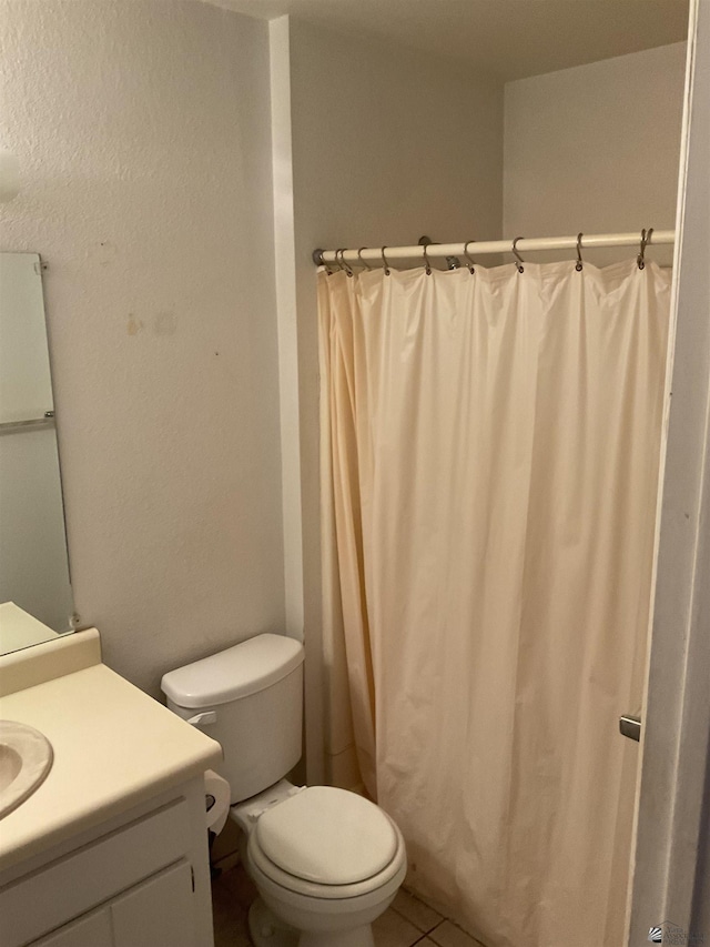 bathroom with tile patterned floors, vanity, and toilet