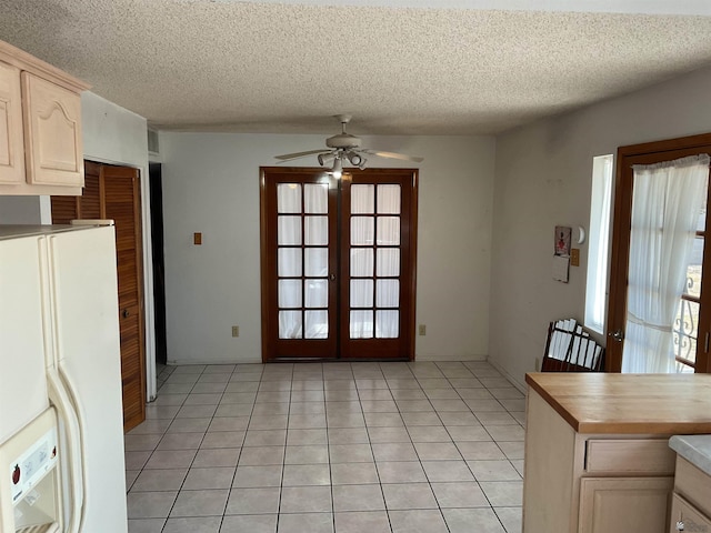 kitchen with light tile patterned floors, ceiling fan, white fridge with ice dispenser, a textured ceiling, and french doors