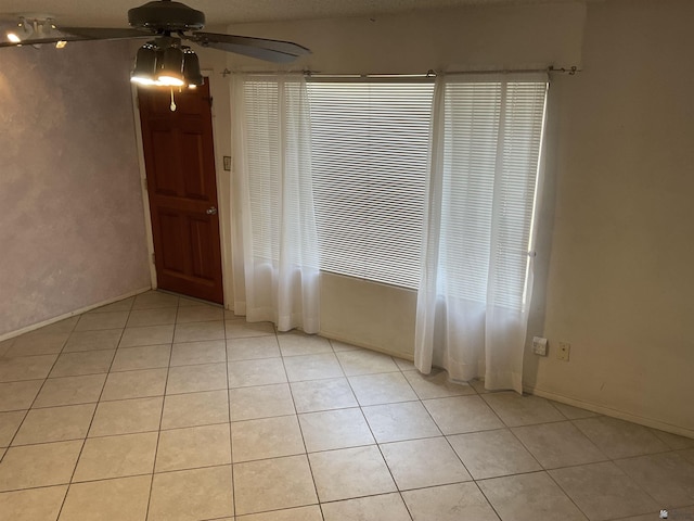 tiled spare room featuring ceiling fan