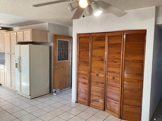 kitchen with light tile patterned floors, a textured ceiling, white fridge with ice dispenser, and ceiling fan