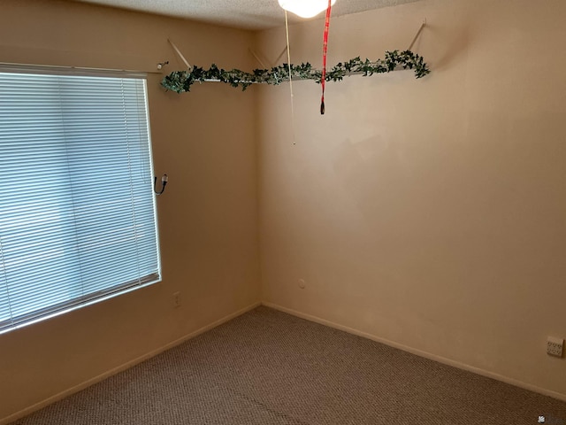 carpeted empty room with a textured ceiling