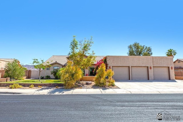 10243 Fairway Loop, Yuma, AZ 85367 - view of front facade with a garage, concrete driveway, stucco siding, and fence