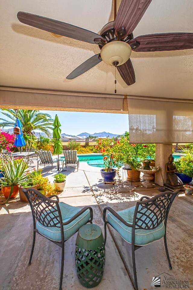 10243 Fairway Loop, Yuma, AZ 85367 - view of patio featuring a ceiling fan, a mountain view, and an outdoor pool