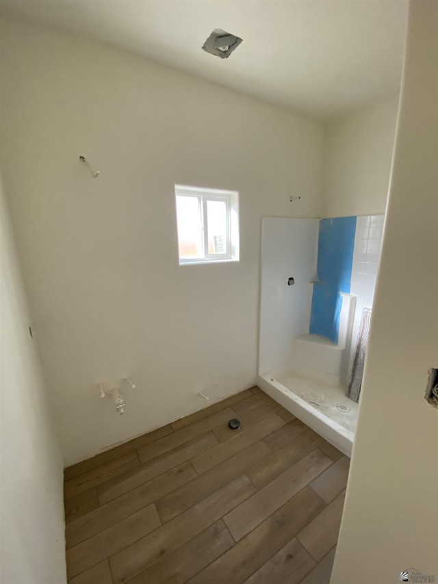 bathroom with a shower and hardwood / wood-style floors