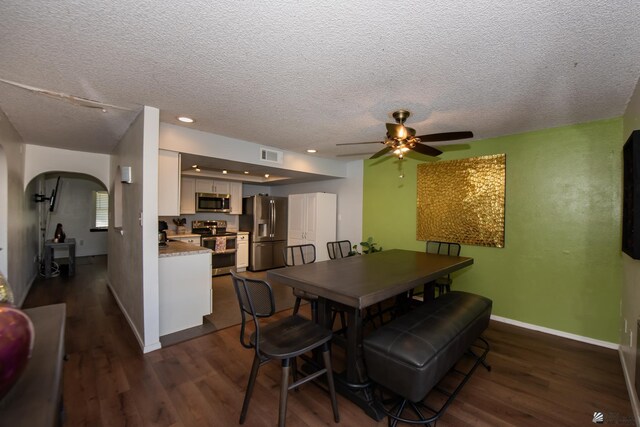 660 E 26th St, Yuma, AZ 85365 - dining area featuring arched walkways, dark wood finished floors, ceiling fan, a textured ceiling, and baseboards