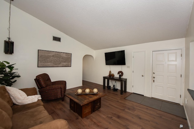 660 E 26th St, Yuma, AZ 85365 - living room with arched walkways, dark wood finished floors, vaulted ceiling, and a textured ceiling