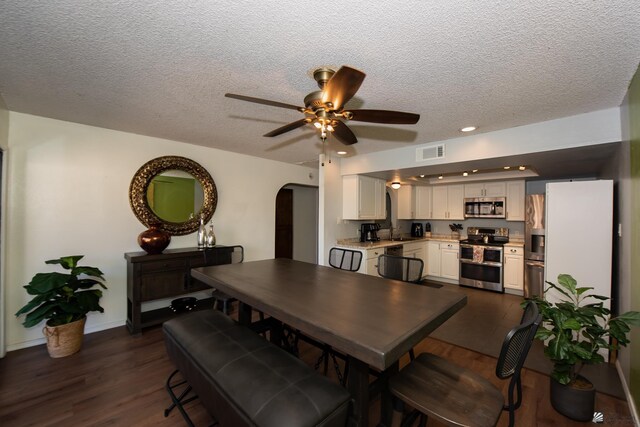 660 E 26th St, Yuma, AZ 85365 - dining space with dark wood-style flooring, a ceiling fan, arched walkways, a textured ceiling, and recessed lighting