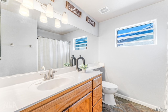 bathroom featuring visible vents, baseboards, toilet, and vanity