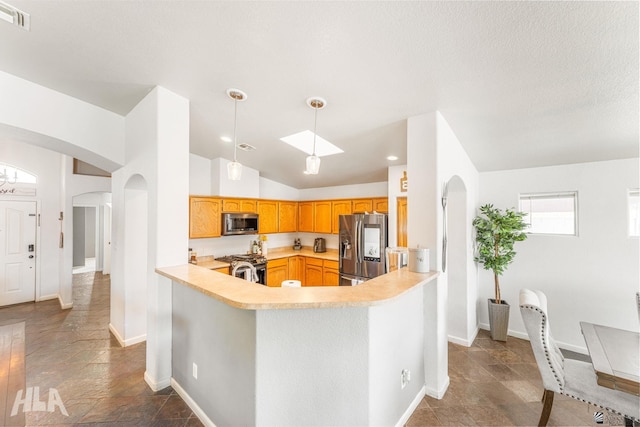 kitchen with light countertops, stainless steel appliances, arched walkways, and visible vents