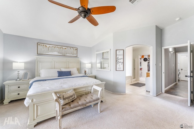 bedroom with light colored carpet, visible vents, arched walkways, baseboards, and vaulted ceiling