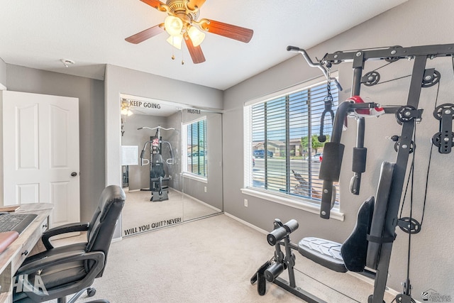 carpeted home office featuring baseboards and a ceiling fan