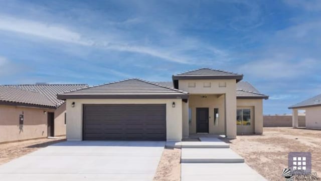 10857 E 45th Pl, Yuma, AZ 85367 - view of front of home featuring a garage, stucco siding, a tiled roof, and concrete driveway