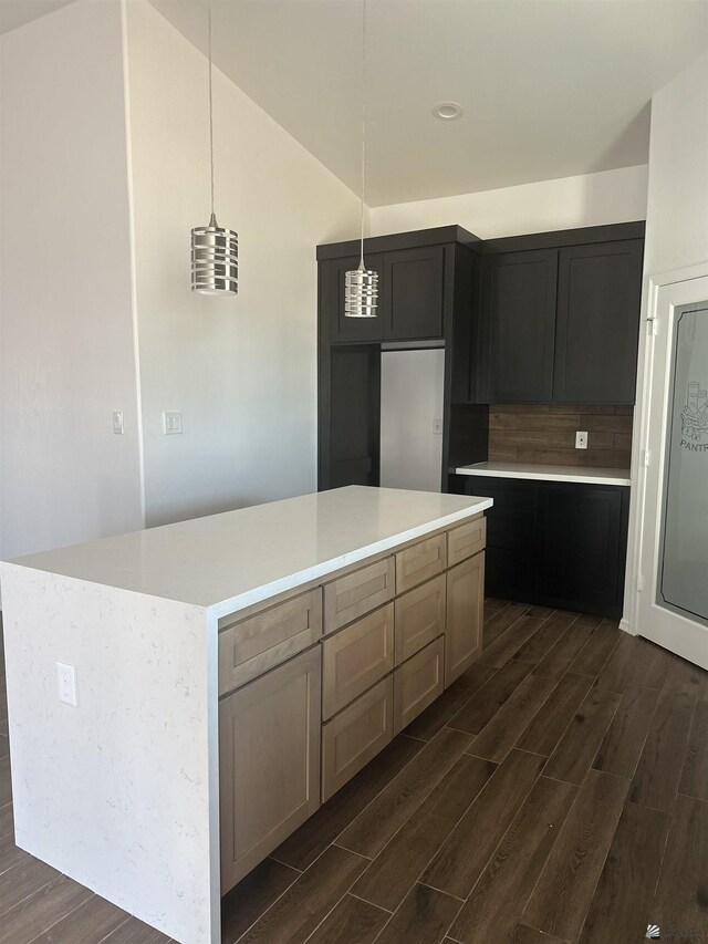 10864 E 45th St, Yuma, AZ 85367 - kitchen featuring dark wood finished floors, decorative backsplash, hanging light fixtures, light countertops, and a kitchen island