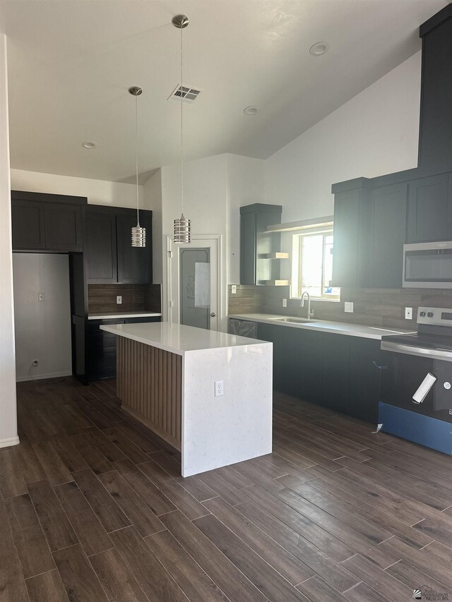 10864 E 45th St, Yuma, AZ 85367 - kitchen featuring stainless steel appliances, open shelves, dark wood-type flooring, a kitchen island, and decorative backsplash