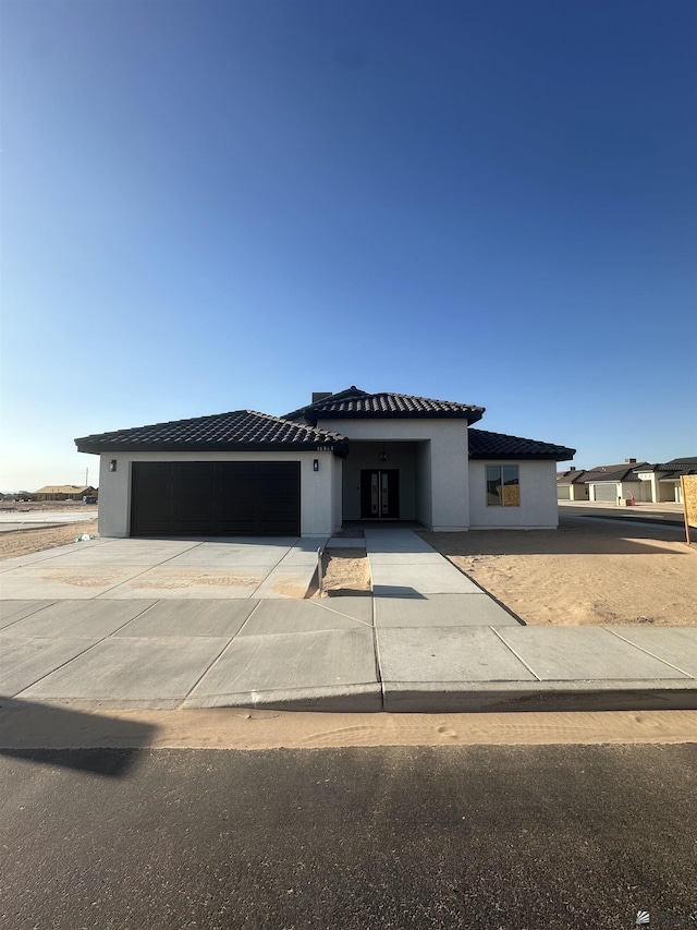 10864 E 45th St, Yuma, AZ 85367 - prairie-style house with a garage, driveway, stucco siding, and a tile roof