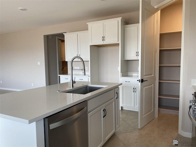 kitchen featuring stainless steel dishwasher, sink, white cabinets, and a kitchen island with sink