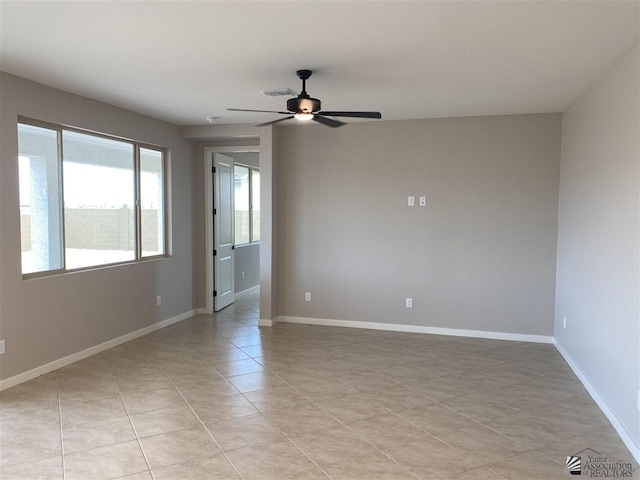 tiled empty room featuring ceiling fan