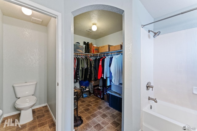 6248 E 42nd Ln, Yuma, AZ 85365 - bathroom featuring tub / shower combination, a spacious closet, and a textured ceiling