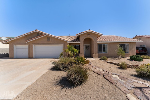 6248 E 42nd Ln, Yuma, AZ 85365 - mediterranean / spanish house featuring an attached garage, stucco siding, concrete driveway, and a tile roof