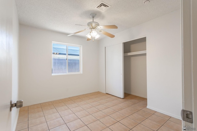 1086 S Arena Dr, Yuma, AZ 85364 - unfurnished bedroom featuring a textured ceiling, light tile patterned flooring, a closet, and ceiling fan