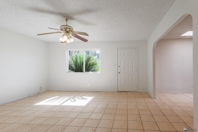 1086 S Arena Dr, Yuma, AZ 85364 - empty room featuring arched walkways, a ceiling fan, a textured ceiling, and light tile patterned floors