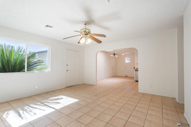 1086 S Arena Dr, Yuma, AZ 85364 - unfurnished room with arched walkways, ceiling fan, a chandelier, a textured ceiling, and light tile patterned floors