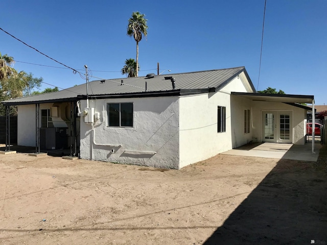 275 E 26th St, Yuma, AZ 85364 - rear view of house featuring a patio, stucco siding, french doors, an attached carport, and metal roof