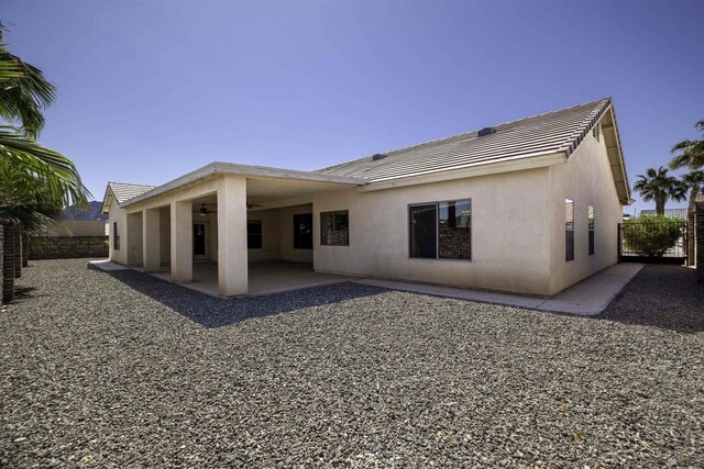 14158 E 49th Dr, Yuma, AZ 85367 - back of property featuring a tiled roof, a ceiling fan, a patio area, fence, and stucco siding
